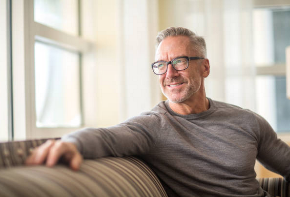 Man sitting on a couch looking forward to a fast inheritance advance loan